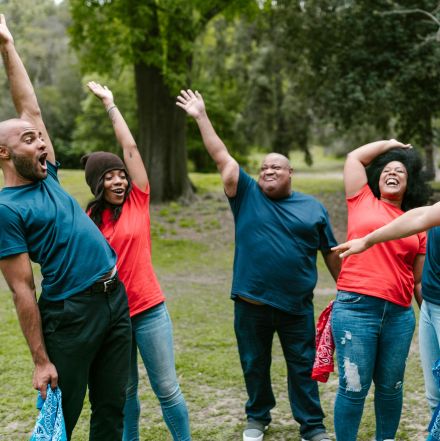 Group of diverse adults enjoying team bonding activities outdoors, radiating joy and togetherness.