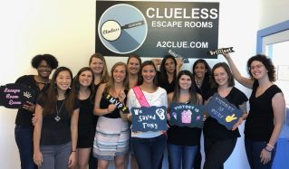 A group of ladies celebrate at Clueless Escape Rooms. They were able to Save Tony just in time.